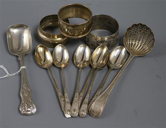 Six silver coffee spoons, a Victorian silver sifter spoon, a silver sorbet? spoon and three silver serviette rings.